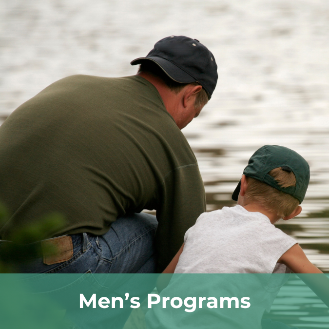 A father an son are skipping stones into water with their backs facing the viewer.There is a text bar on the bottom of the image that reads Men's Programs.